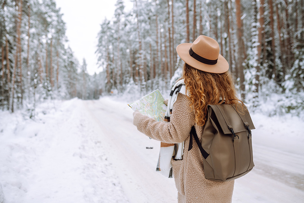 Woman looking at a map on a snowy road