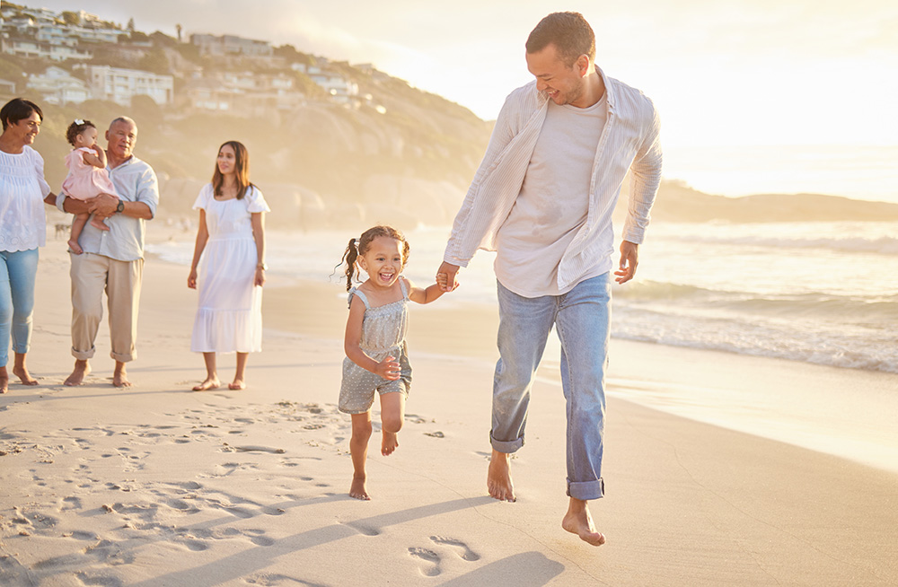 A family walking along the beach at sunset